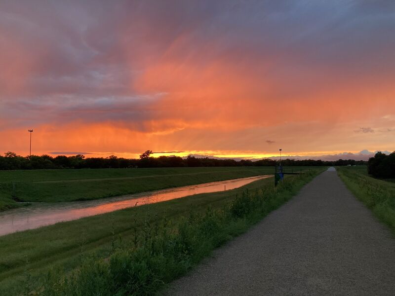 The West Fork at sunset, storm colour over the river and the trail running alongside it.
